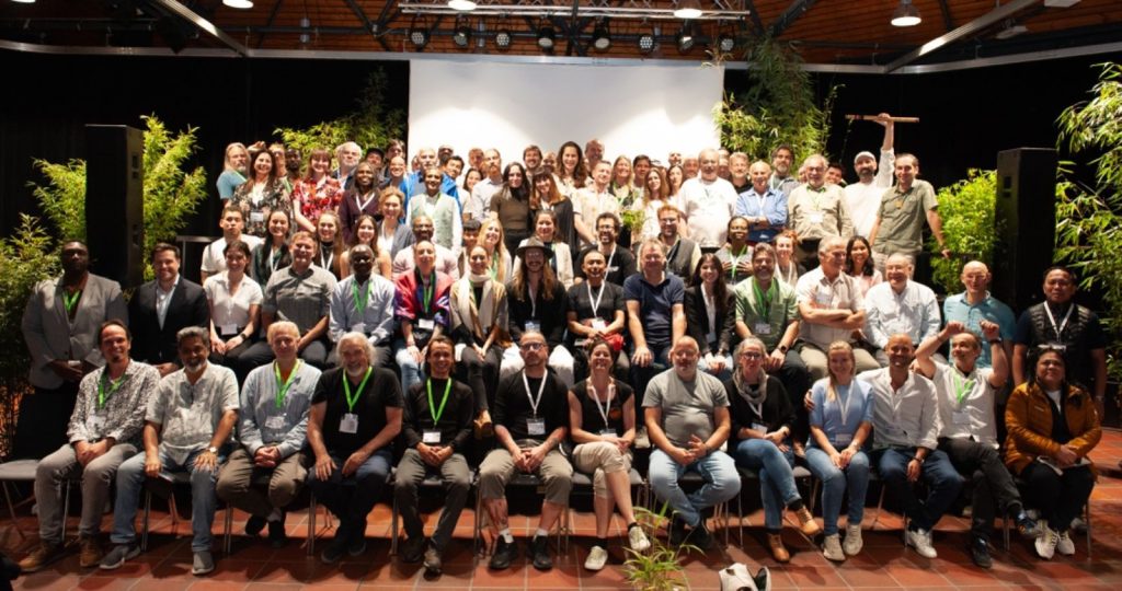 A group of people from a range of places in rows across the stage in a posed photo at the end of the event.