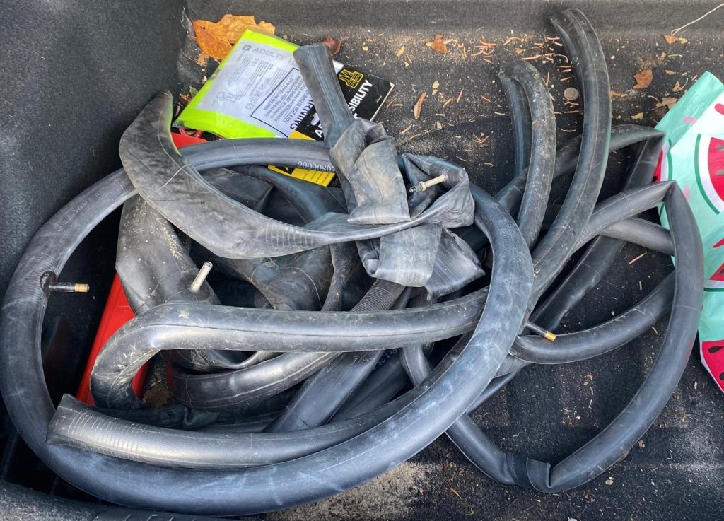 A pile of black rubber inner tubes in a car boot.